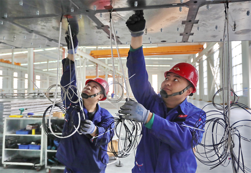 工人在“光伏智能装备制造中心项目”的太阳能层压机生产线工作中。曹建雄摄